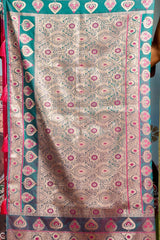 Decorative fabric with intricate patterns and colors, held by a person.