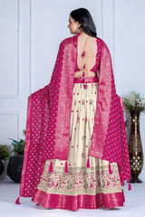 Woman wearing a traditional outfit with a pink dupatta in a minimalistic setting