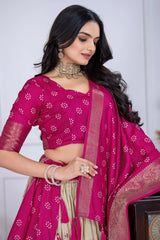 Woman wearing a pink saree with a white blouse against a plain background