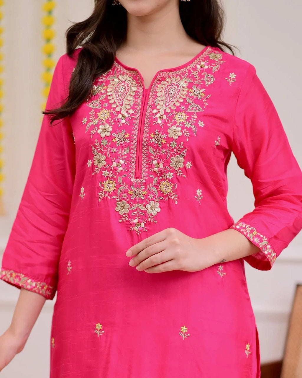 Pink embroidered kurta worn by a person against a neutral background