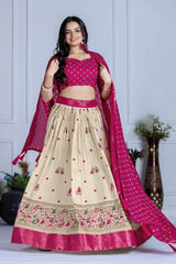 Woman wearing a traditional outfit with a pink and beige lehenga against a white background