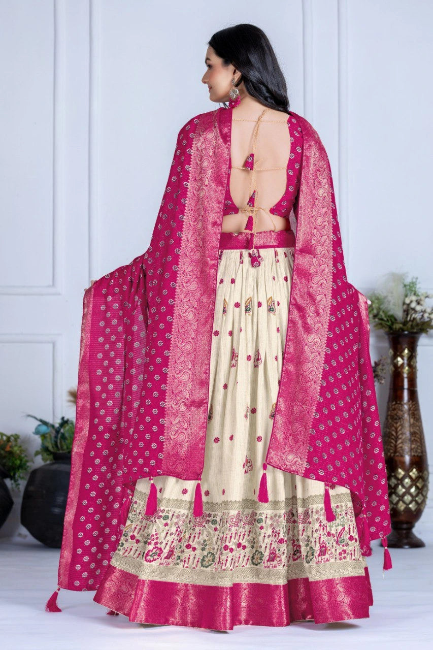 Woman wearing a traditional outfit with a pink dupatta and white skirt in a minimalistic setting.