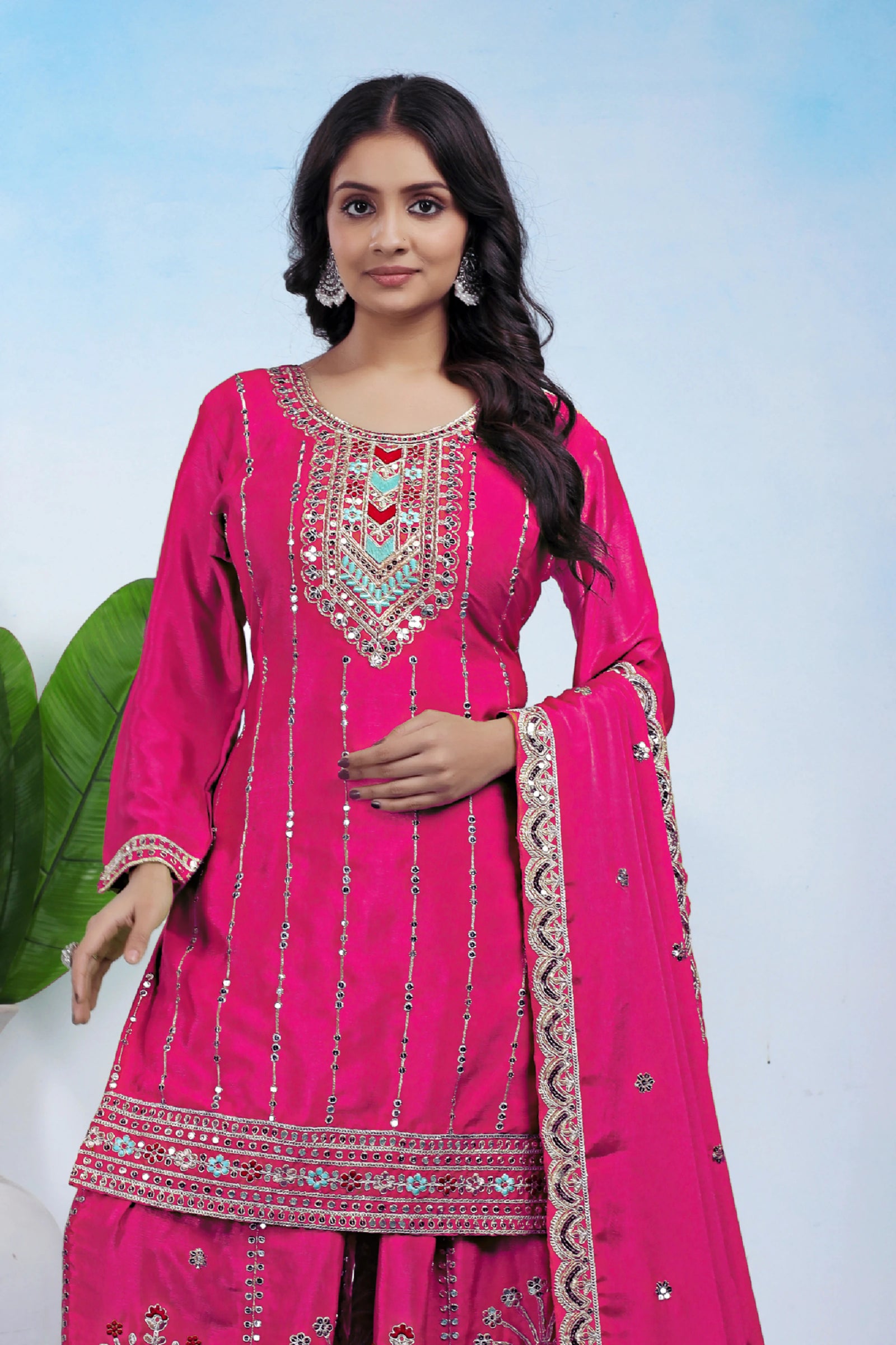 Woman wearing a pink embroidered traditional outfit with a white background
