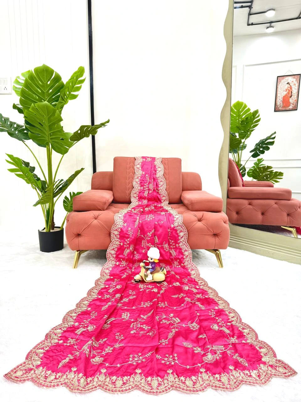 Pink embroidered saree with a mirror reflection in a living room setting