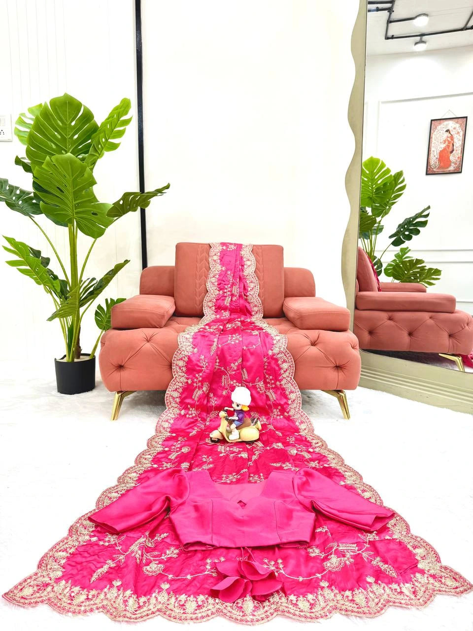 Pink embroidered saree with a decorative stand in a living room setting