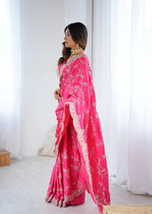 Woman wearing a bright pink saree with white patterns in a minimal indoor setting