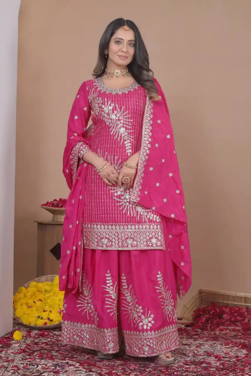Woman wearing a pink embroidered traditional outfit with a beige background