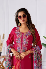 Woman wearing a pink embroidered outfit with a colorful scarf against a white background