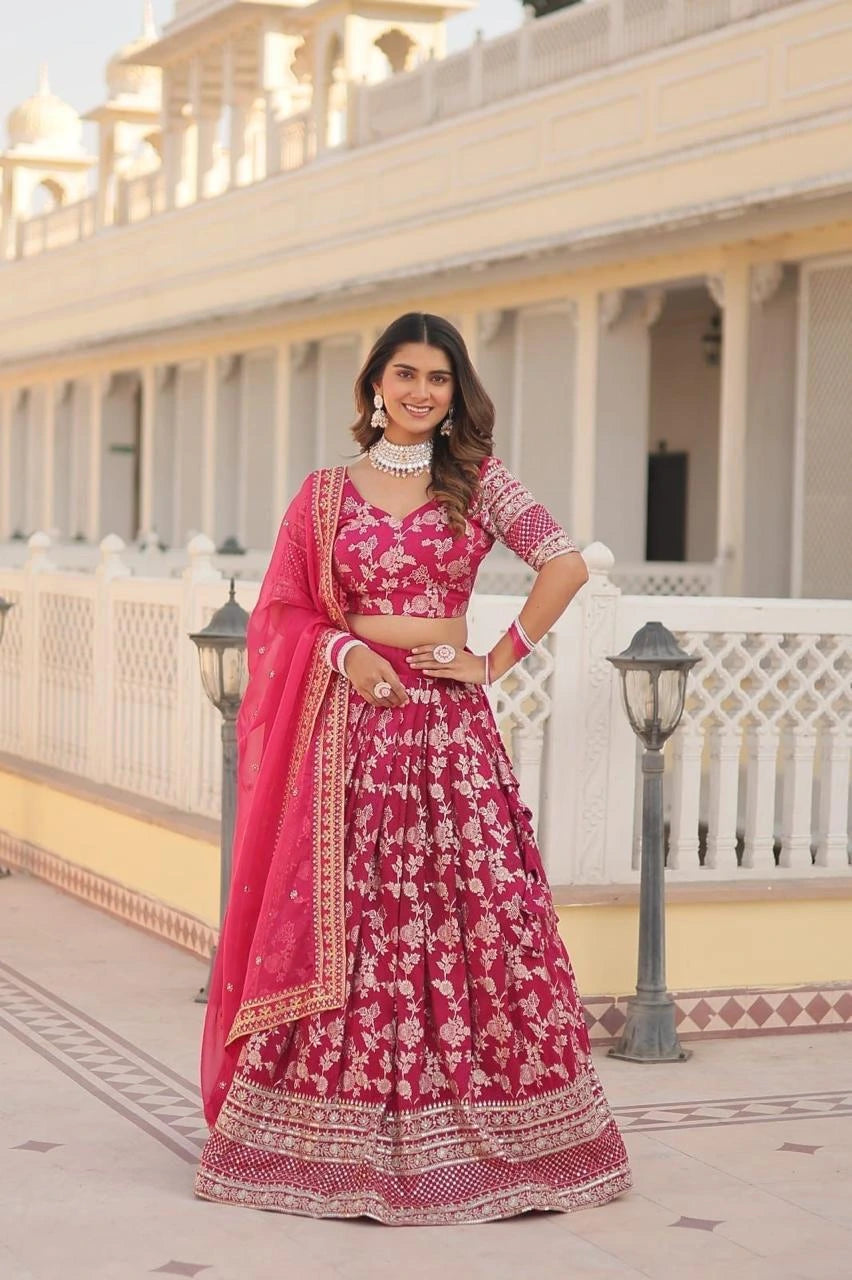 Woman in a red and white traditional outfit standing in front of a building with columns.