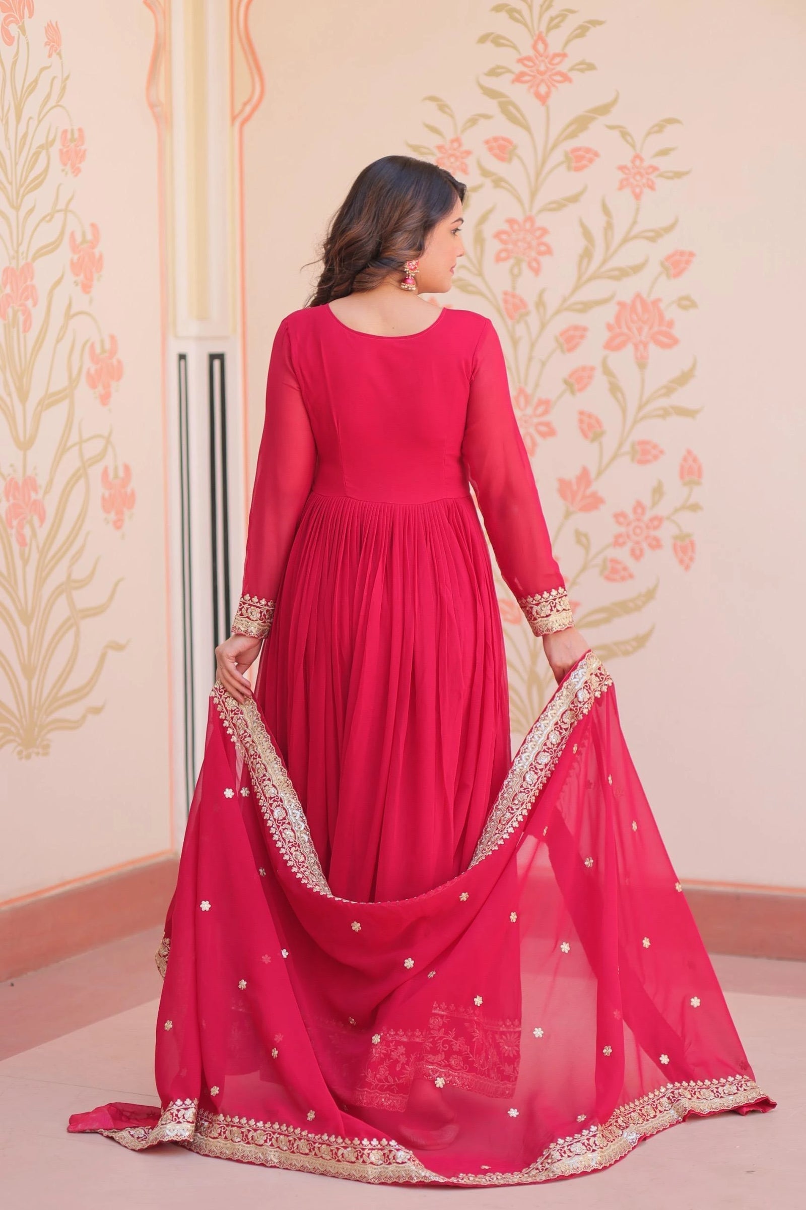 Woman in a red traditional outfit with a pink floral background