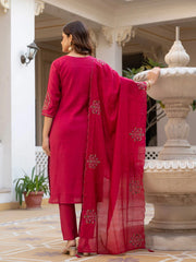 Woman in a red traditional outfit standing in front of a decorative fountain.