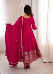 Woman wearing a pink traditional outfit with a matching dupatta in a bright room.