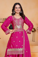 Woman wearing a pink traditional outfit with intricate designs on a beige background