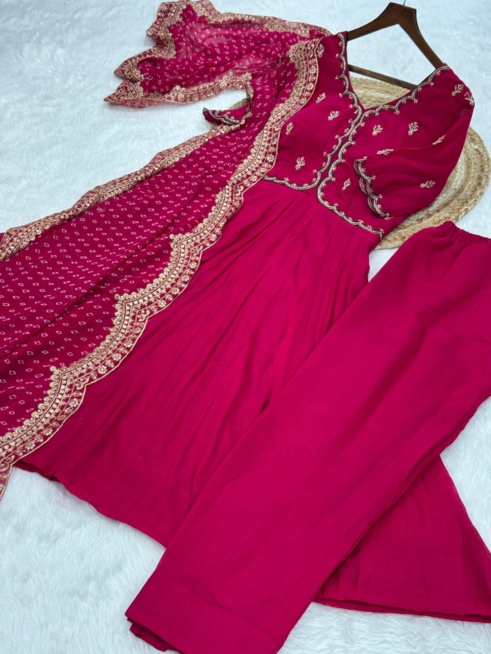 Red traditional outfit with intricate gold embroidery on a white background