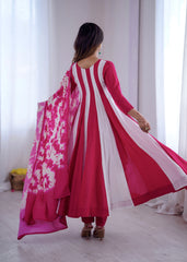 Woman wearing a pink and white traditional outfit with a matching dupatta in a bright room.