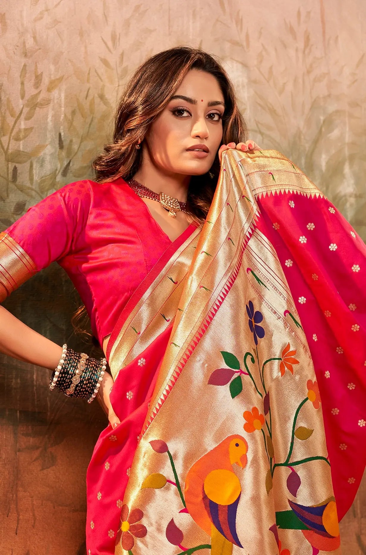 Woman wearing a traditional saree with a floral design against a neutral background