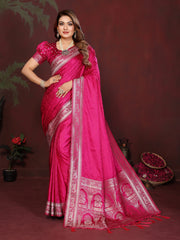 Woman wearing a pink saree with intricate designs on a dark background