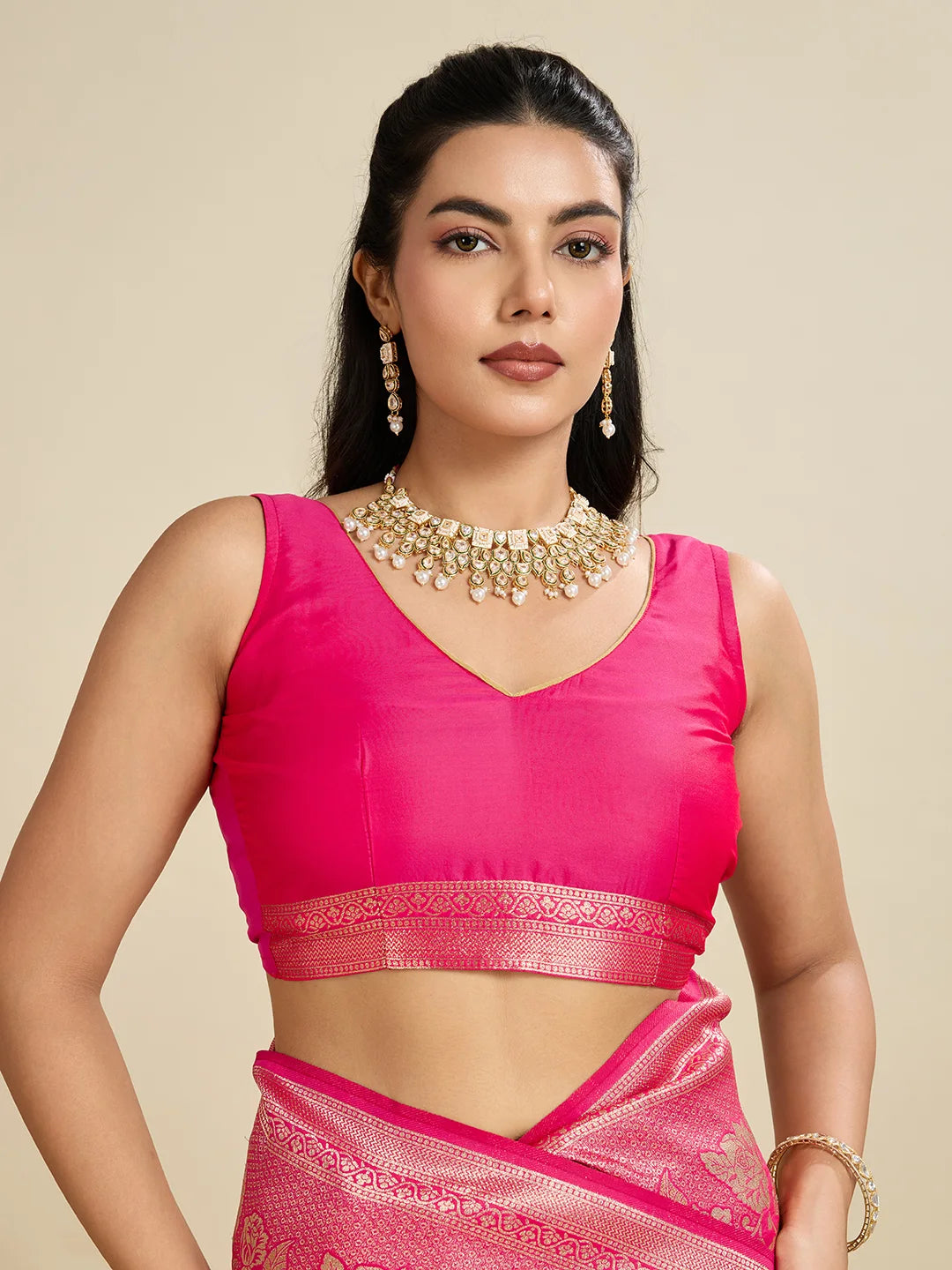 Woman wearing a pink traditional outfit with jewelry on a beige background