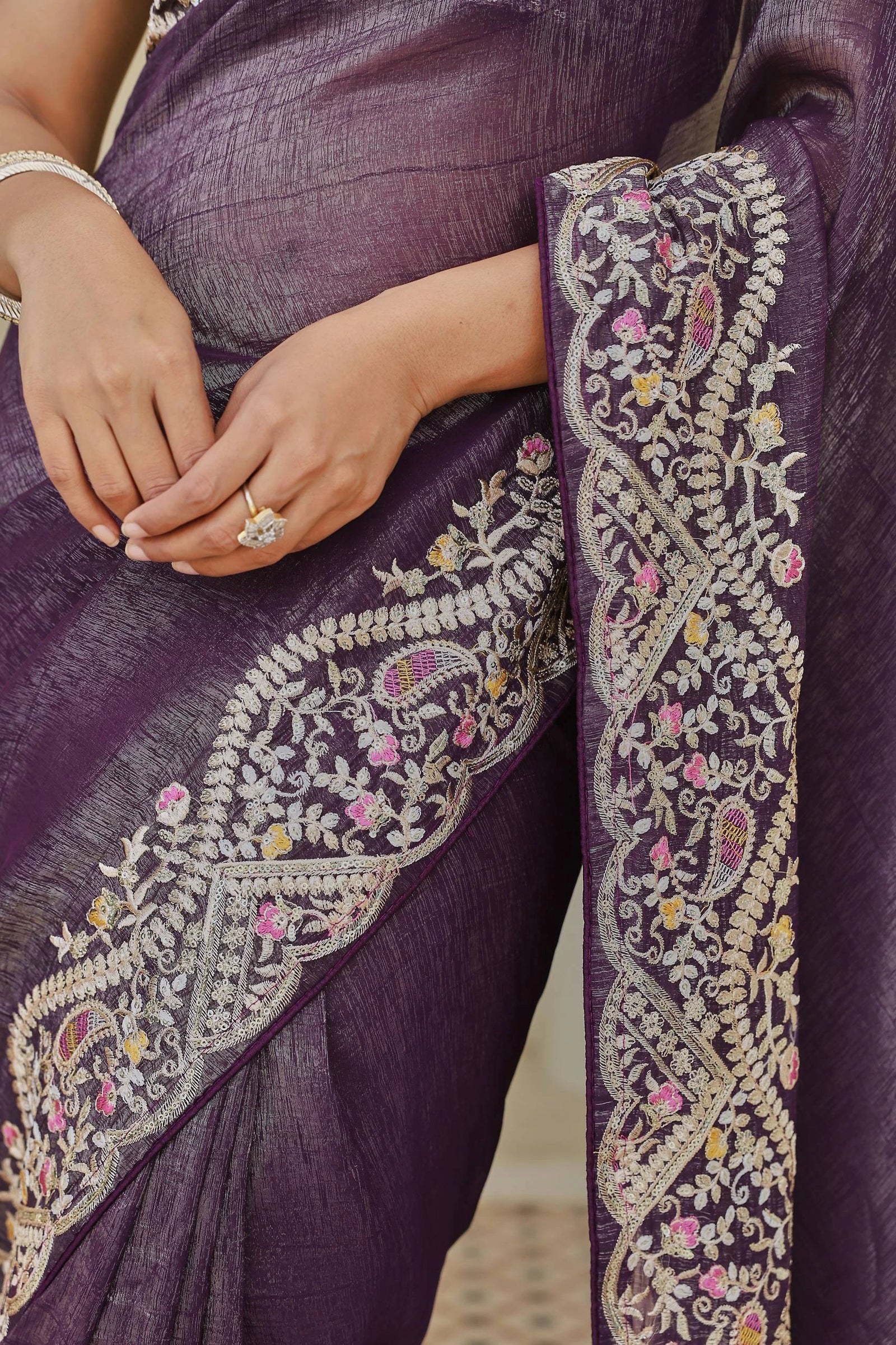 Close-up of a purple saree with intricate white embroidery