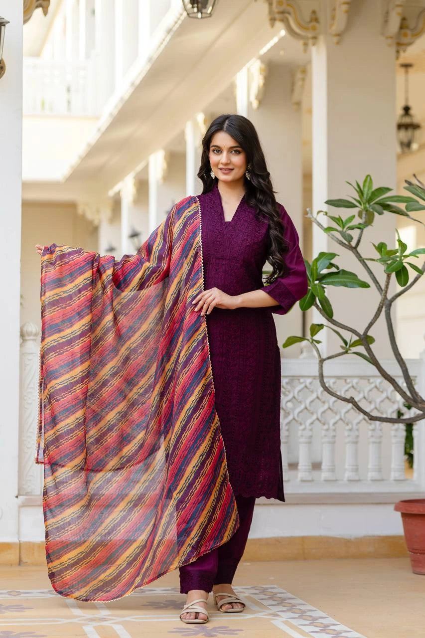 Woman in a purple outfit with a colorful scarf in an elegant indoor setting
