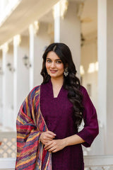 Woman in a purple outfit with a colorful shawl standing outdoors.