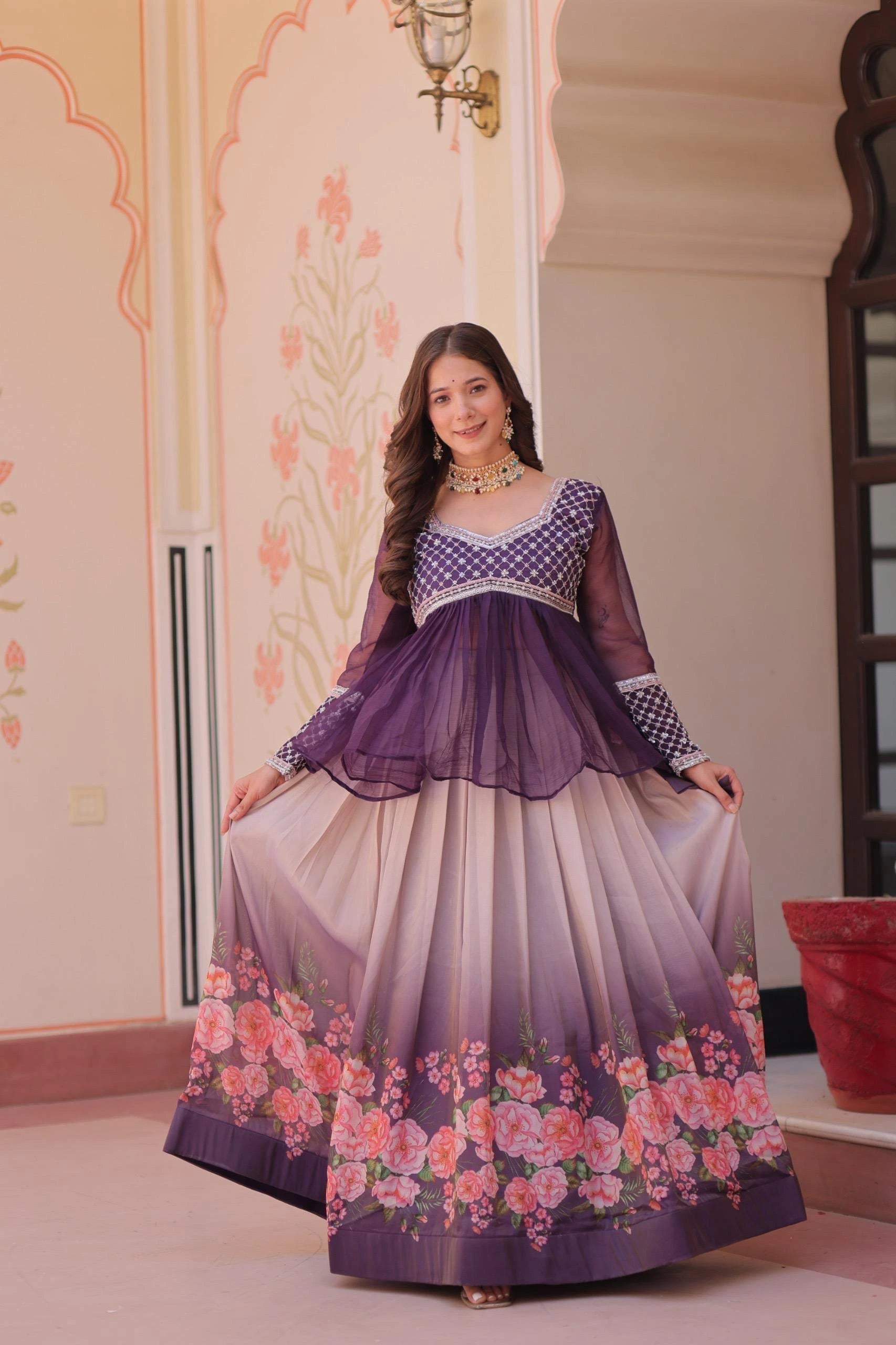 Woman wearing a purple and white dress with floral design indoors.