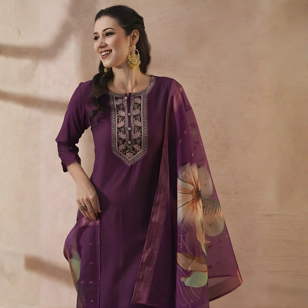 Woman wearing a purple traditional outfit with floral design on a beige background
