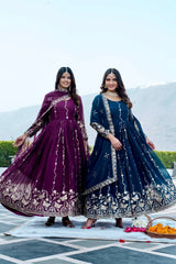 Two women in traditional embroidered dresses standing outdoors with a scenic background.
