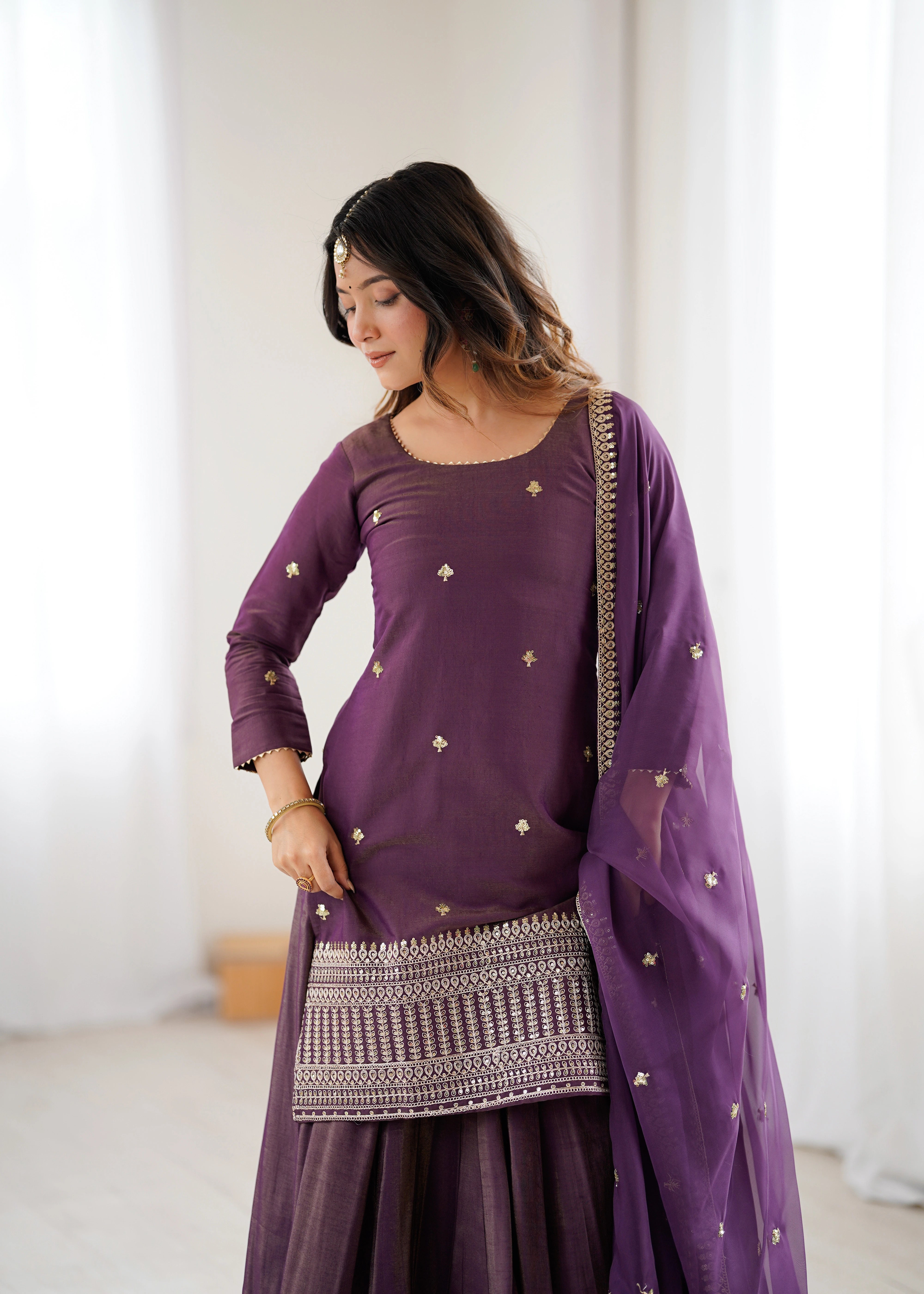 Woman wearing a purple traditional outfit with a white background