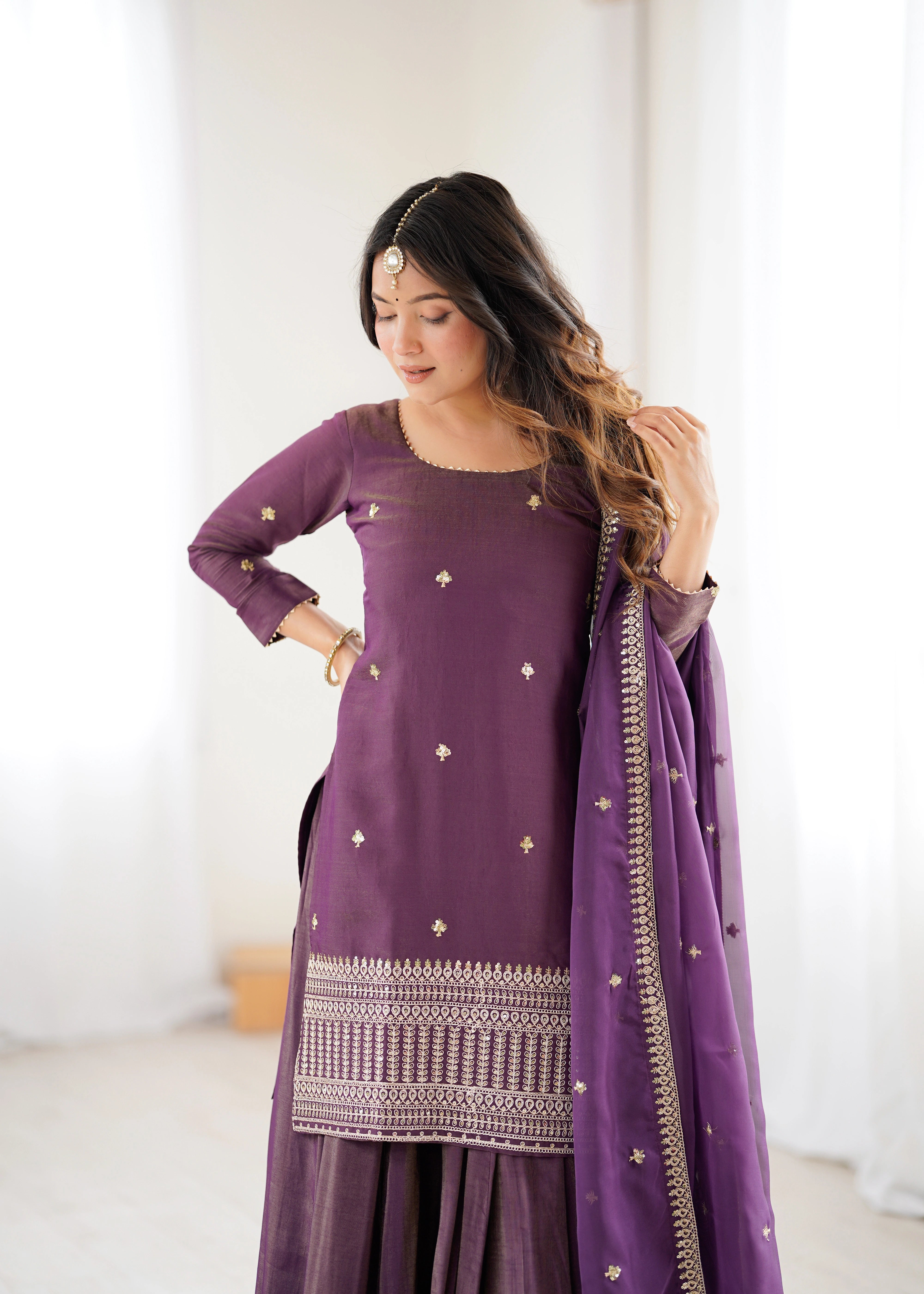 Woman wearing a purple traditional outfit with a white background