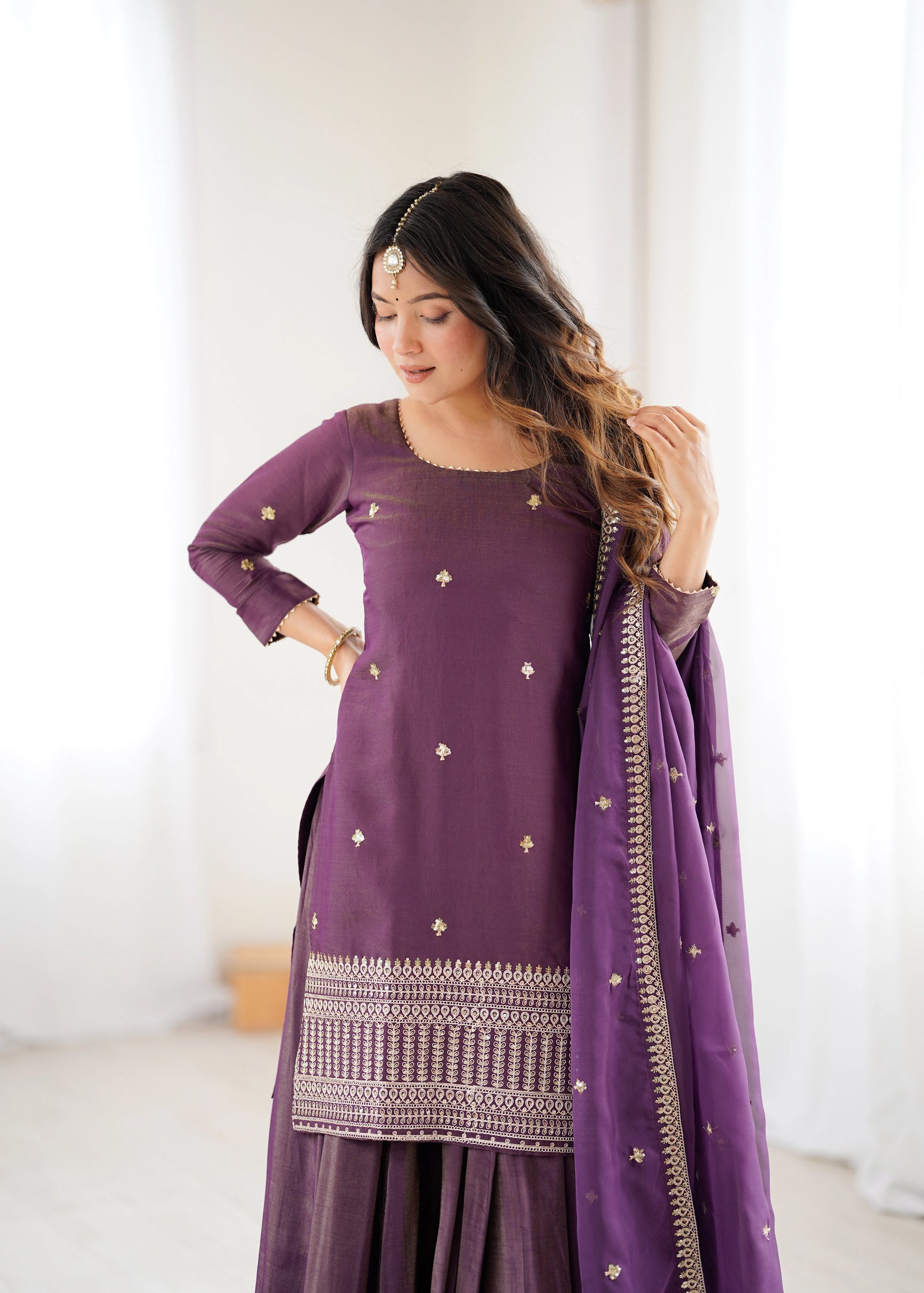 Woman wearing a purple traditional outfit with a white background