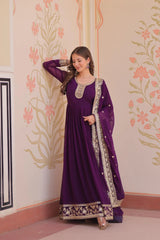 Woman in a purple traditional outfit with floral wall design
