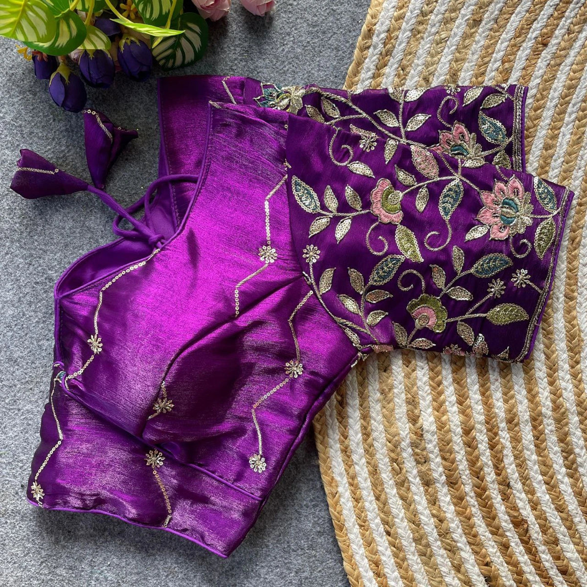 Purple saree with floral embroidery on a textured surface