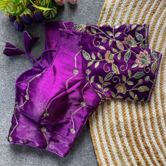 Purple saree with floral embroidery on a textured surface
