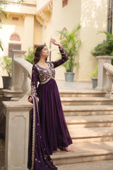 Woman in a purple traditional outfit standing on steps outdoors.