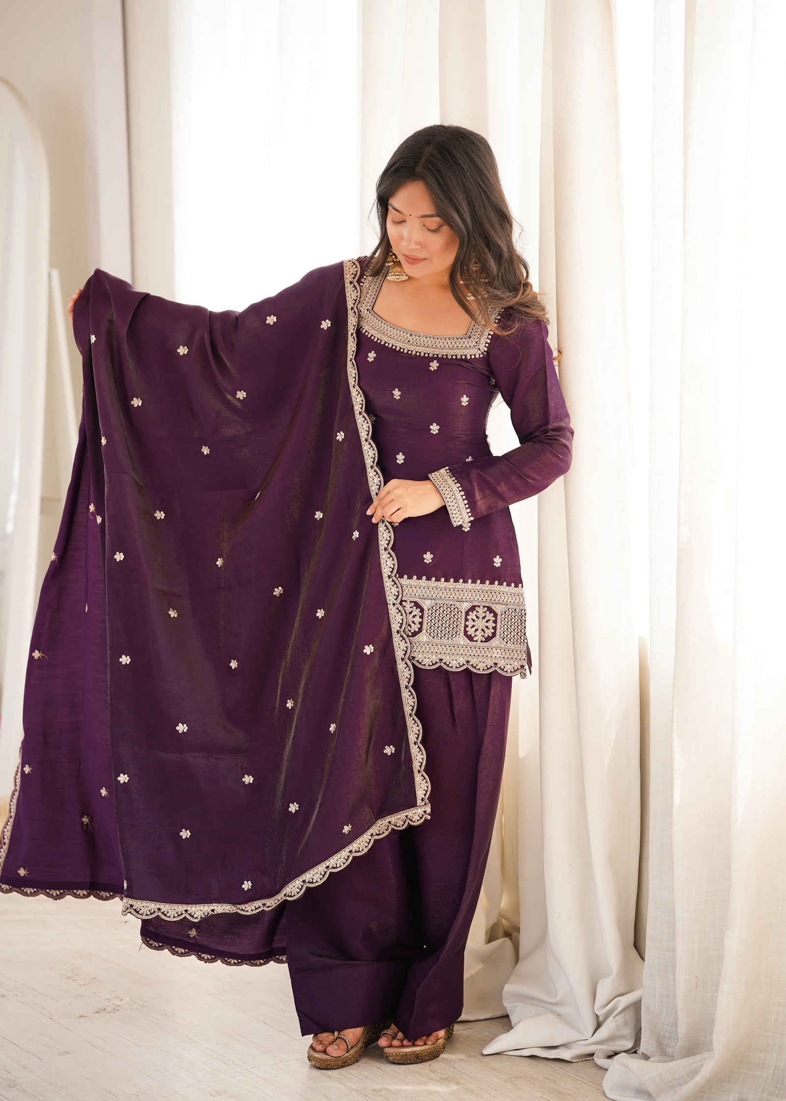 She gracefully drapes a matching sheer dupatta adorned with delicate embellishments.