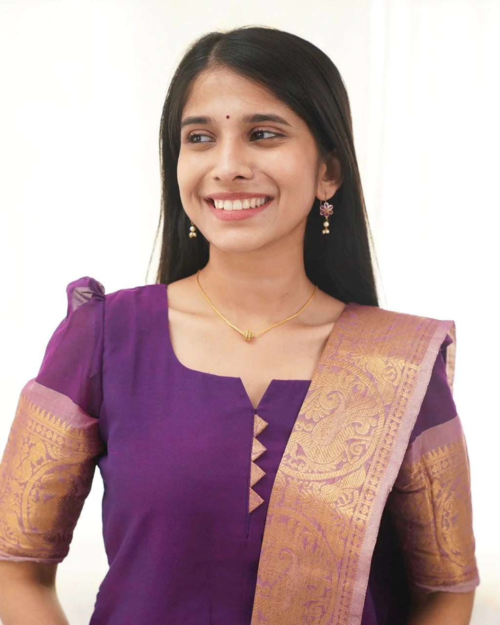 Woman wearing a purple traditional outfit with gold patterns on a white background