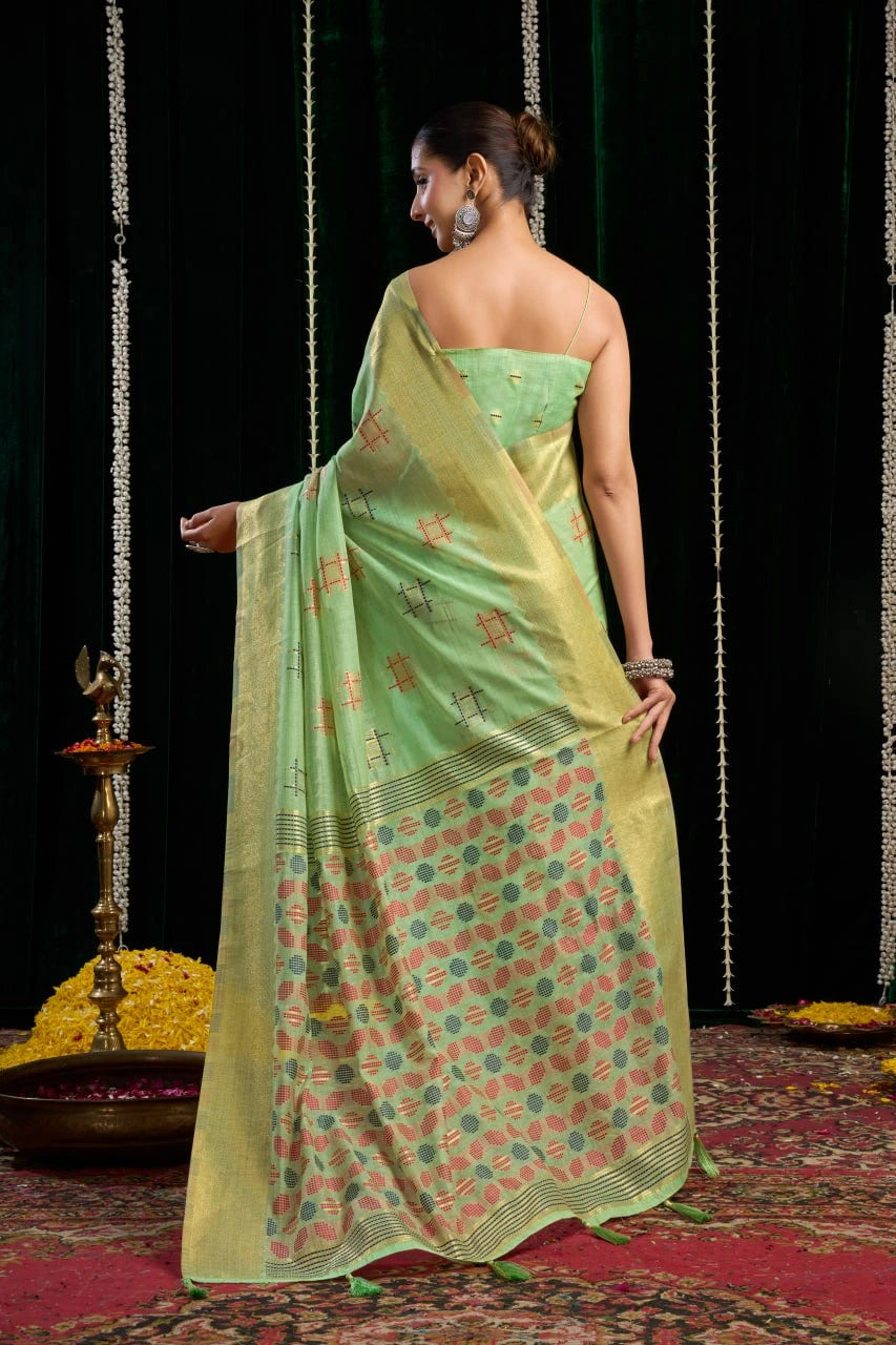 Woman in a green saree with floral patterns on a dark background