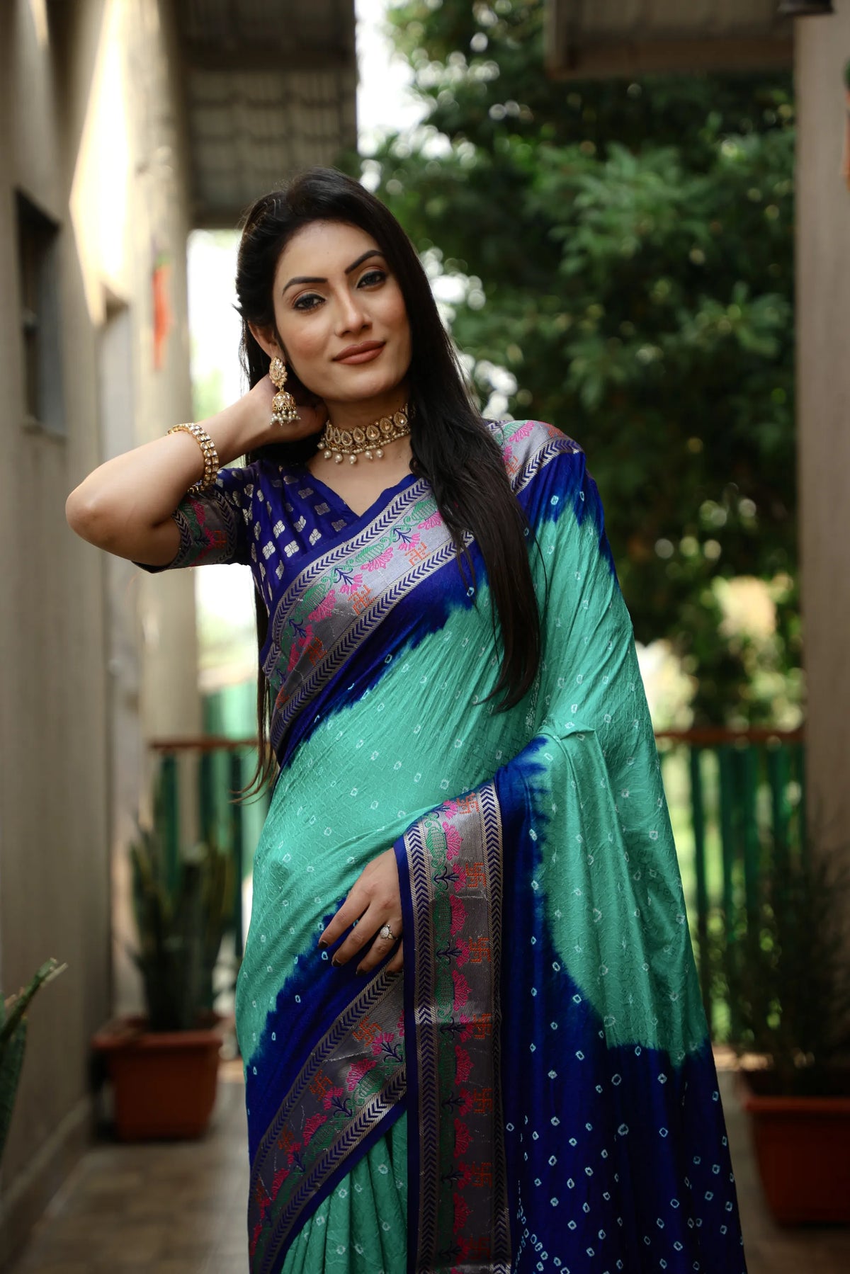Woman wearing a blue and green saree with a blurred background