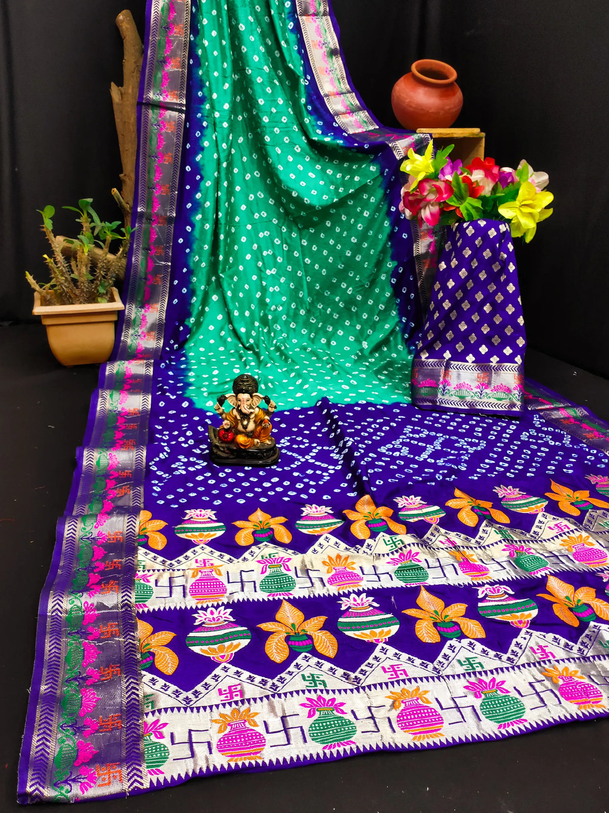 Colorful saree with a patterned tablecloth and decorative items on a black background