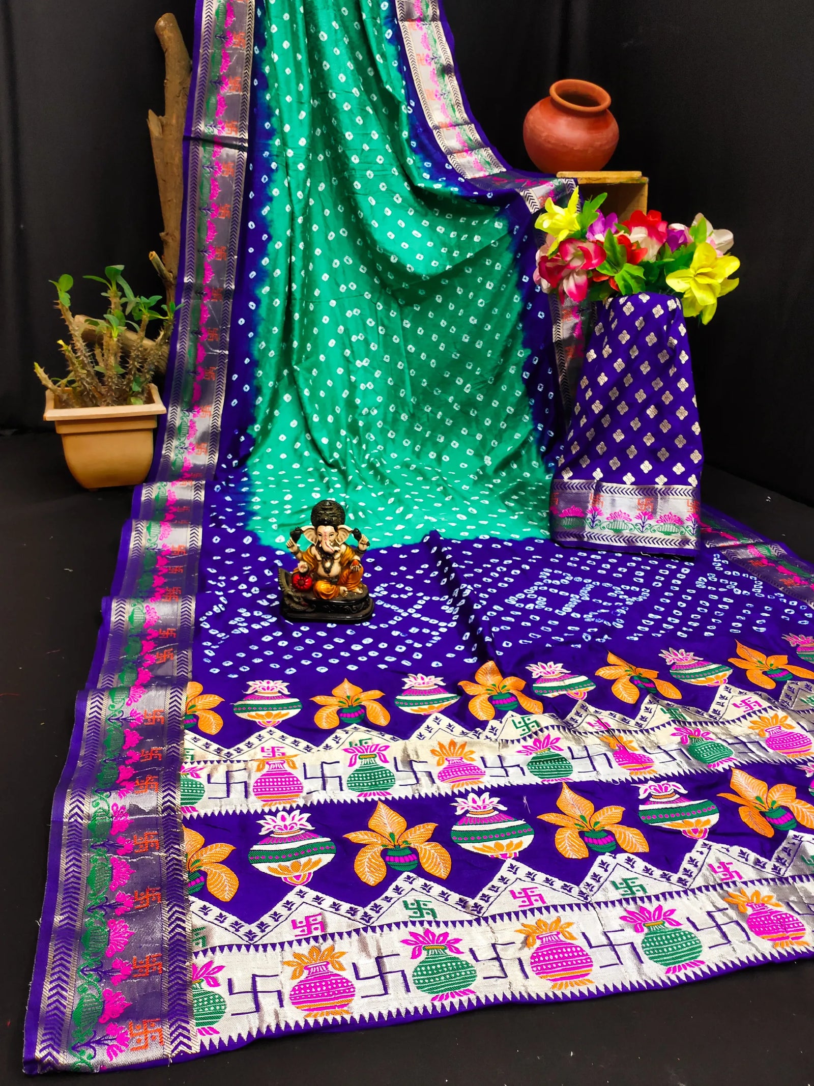 Colorful saree with a patterned tablecloth and decorative items on a black background