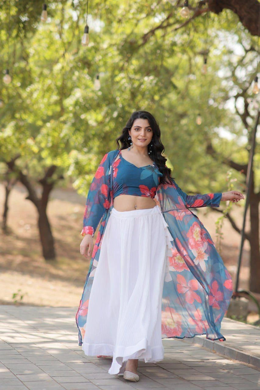 Woman in a blue top and white skirt with a floral jacket outdoors