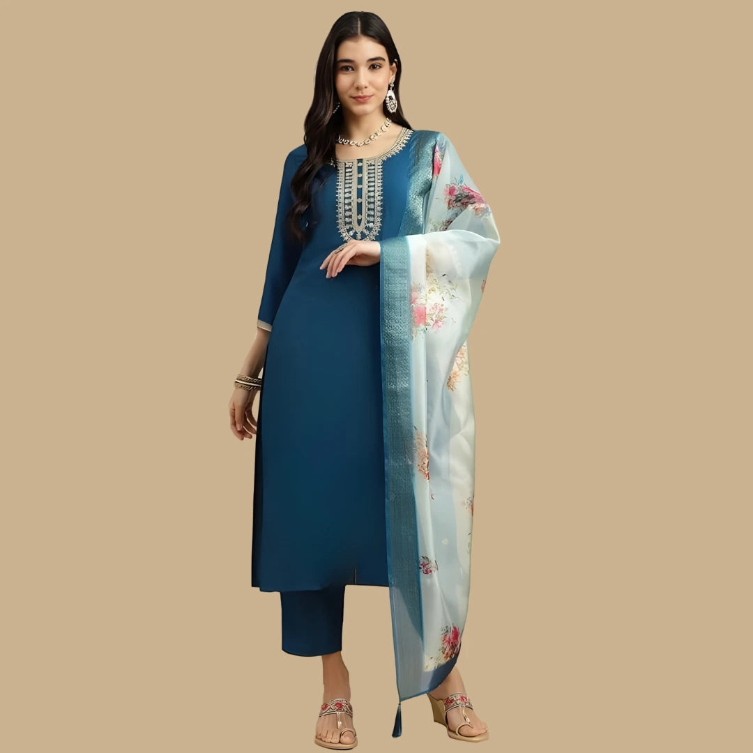 Woman wearing a blue traditional outfit with a floral scarf on a beige background