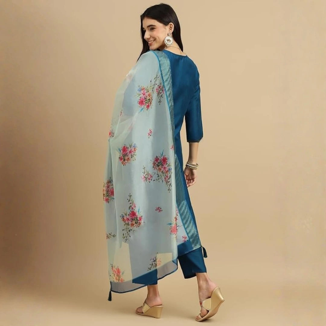 Woman wearing a blue floral saree with a beige background