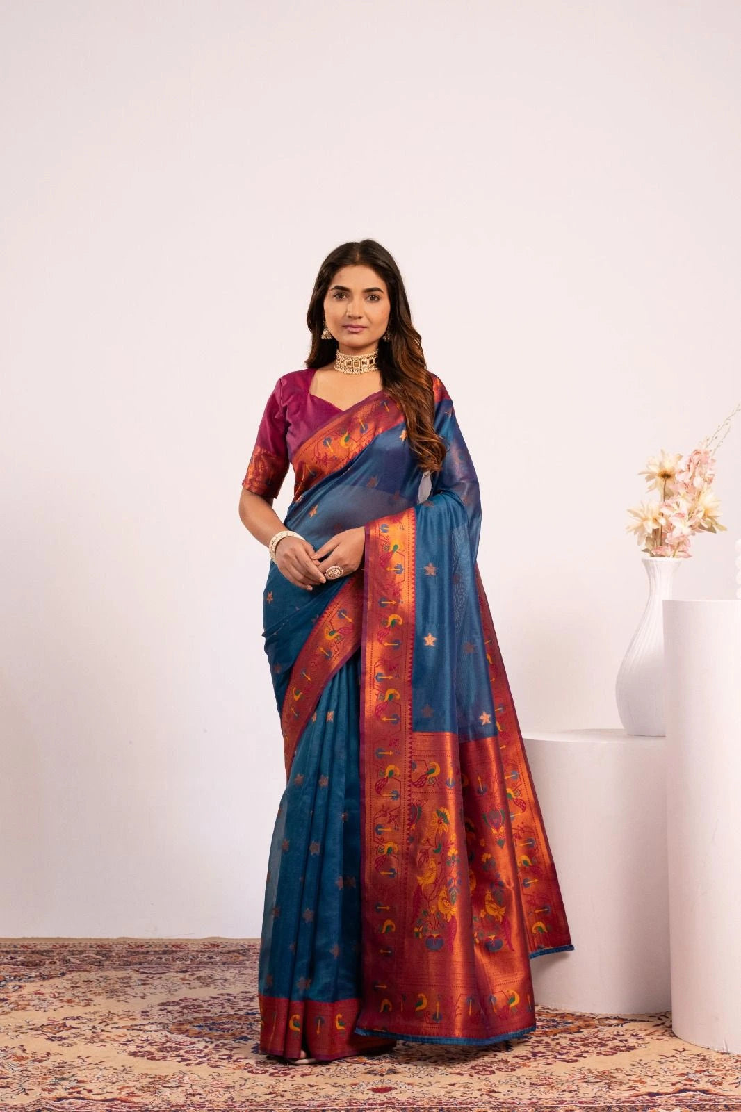Woman wearing a blue and red saree with a white background