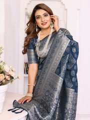 Woman wearing a blue and gray saree with jewelry indoors