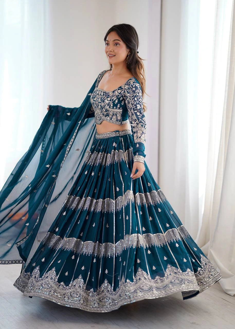 Woman in a traditional blue and silver outfit with a white curtain background