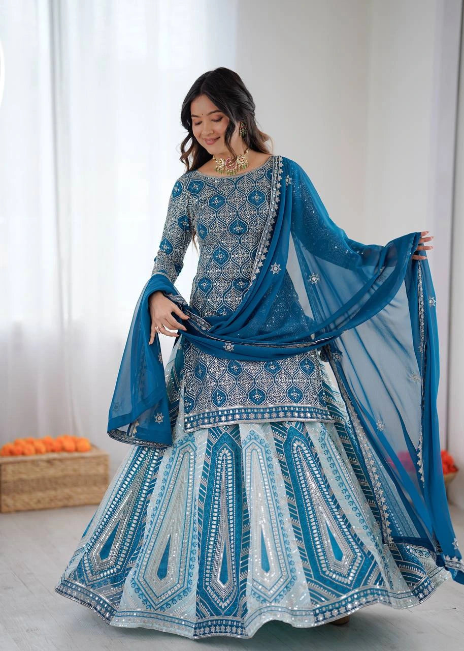 Woman wearing a blue and white embroidered traditional outfit with a matching dupatta.