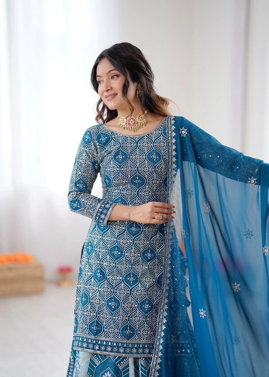 Woman wearing a blue and white patterned traditional outfit with a matching dupatta.