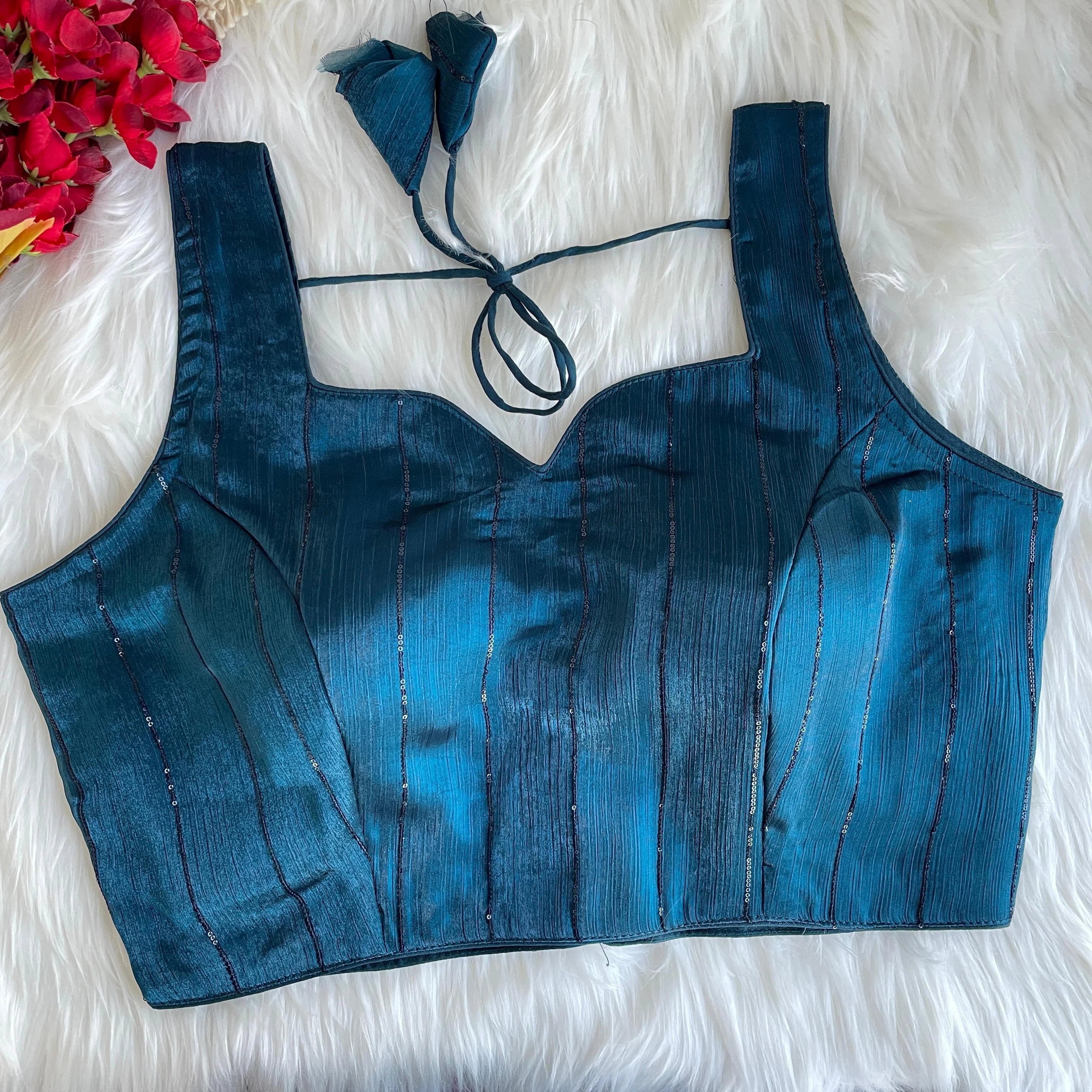 Blue top on a white fluffy surface with floral decorations